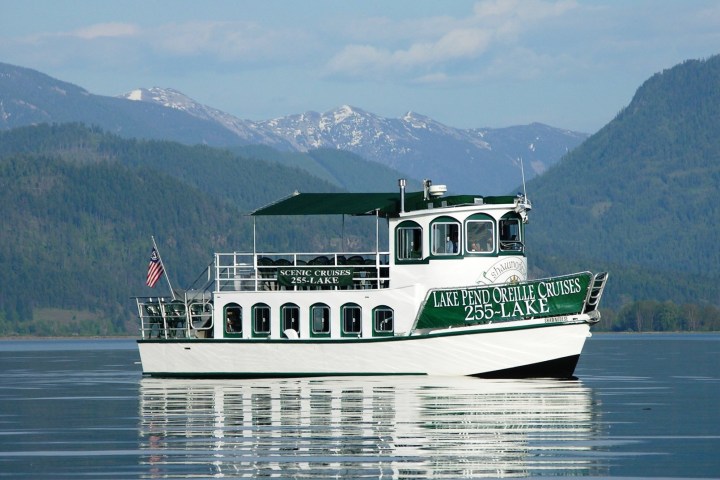 a large ship in a body of water with a mountain in the background